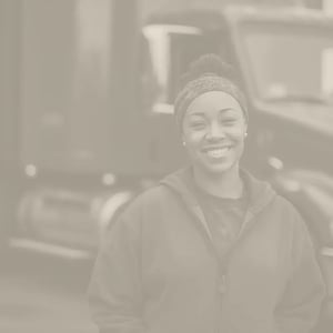 Female truck driver poses in front of her semi truck