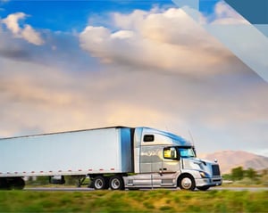 white commercial truck drives along a road