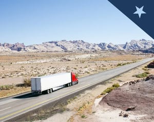 Red semi truck drives along a lone road